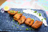 Close-up of golden fried fish fillets accompanied by lemon wedges and fresh herbs.