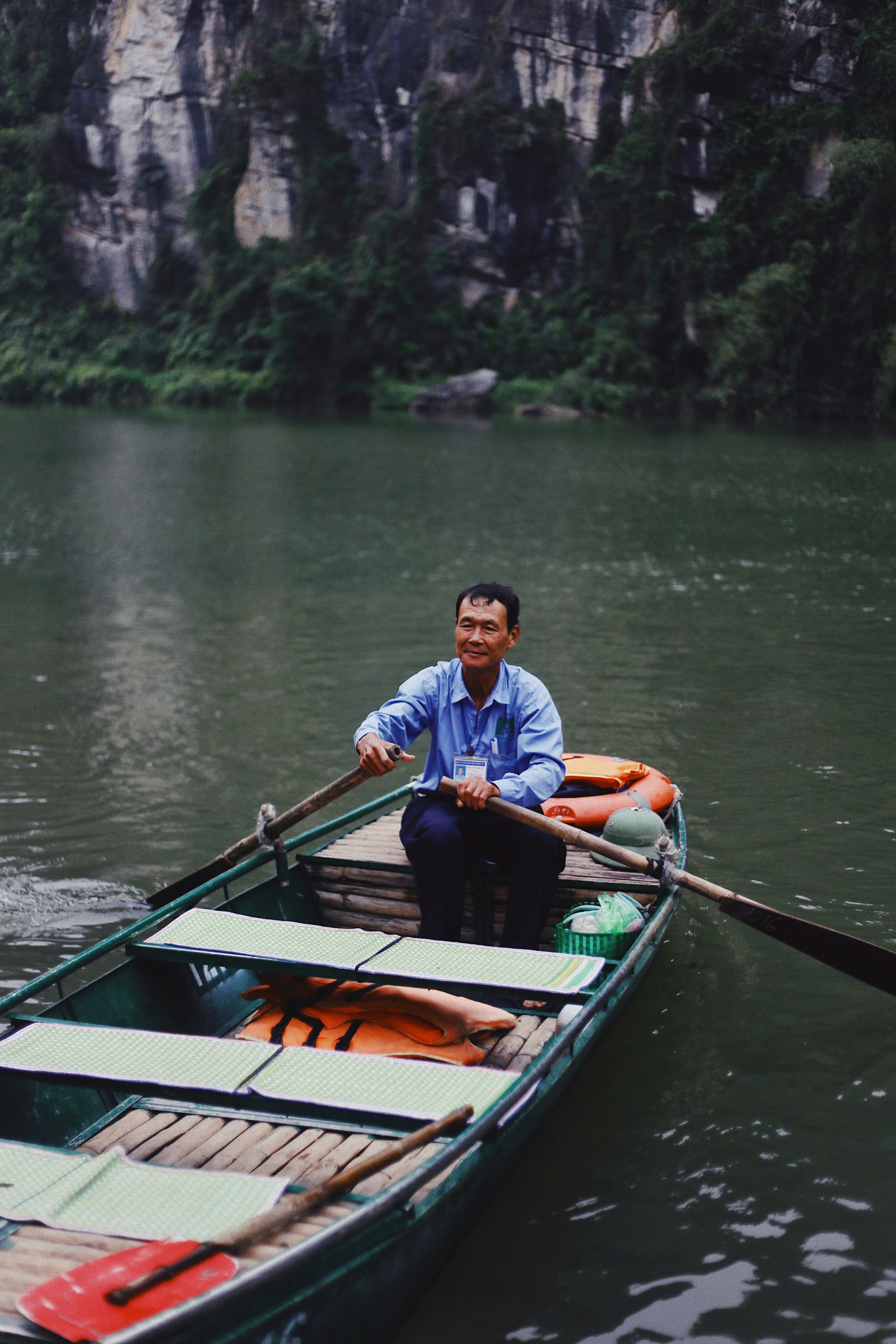 man sitting on boat and paddling