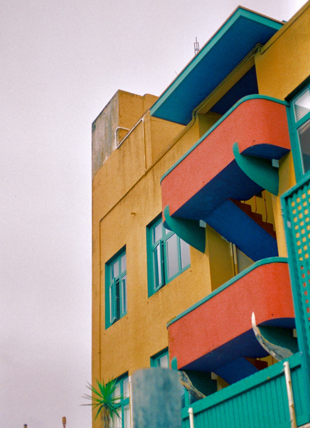 Edifício de 4 andares laranja, azul e amarelo