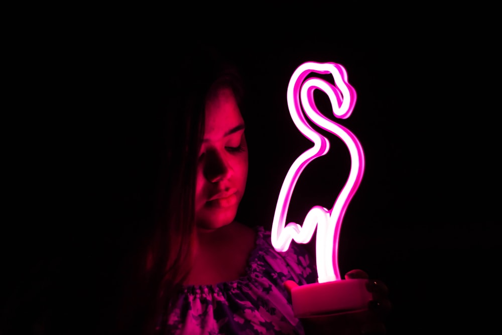 woman holding flamingo LED lamp