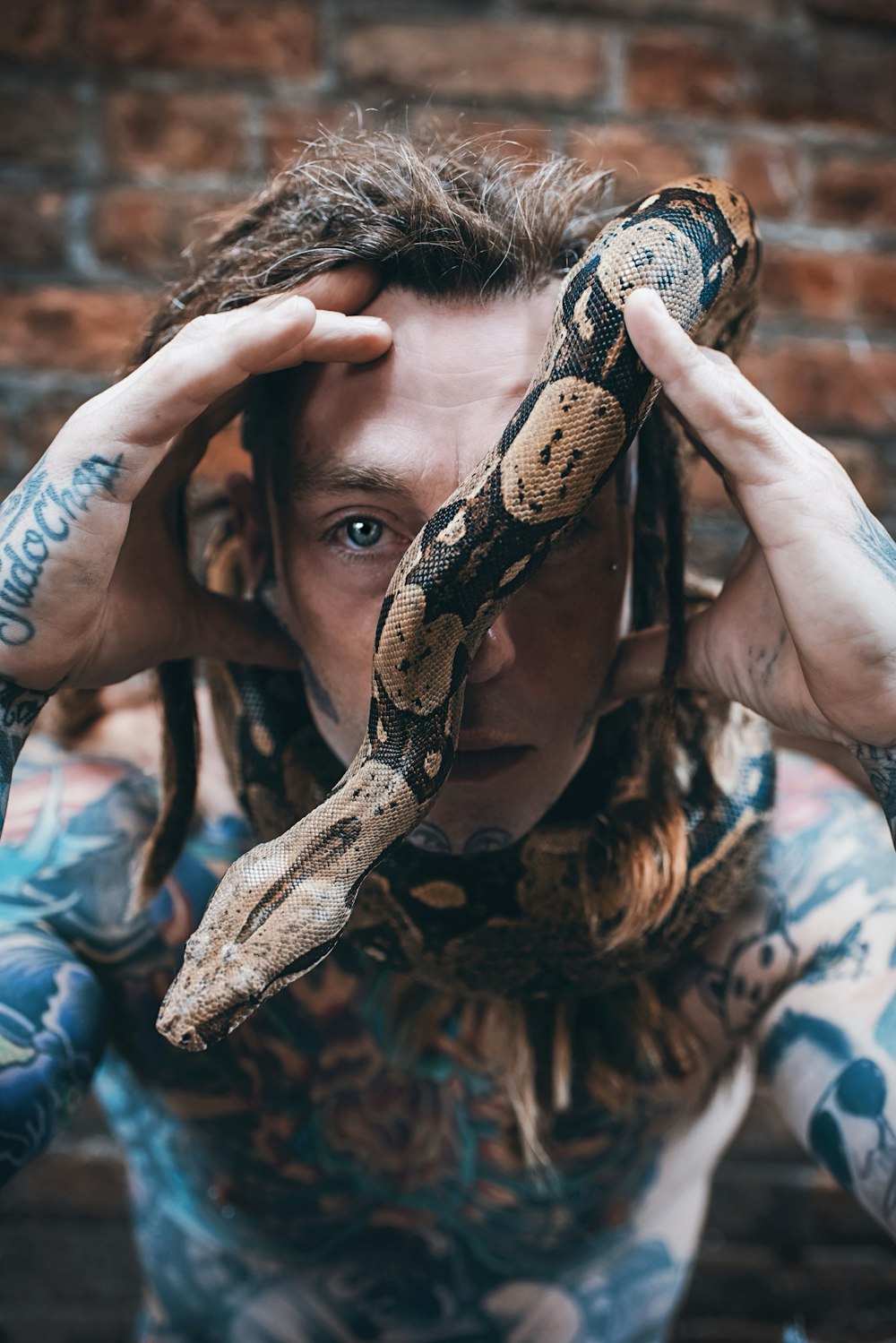 man holding brown and black snake