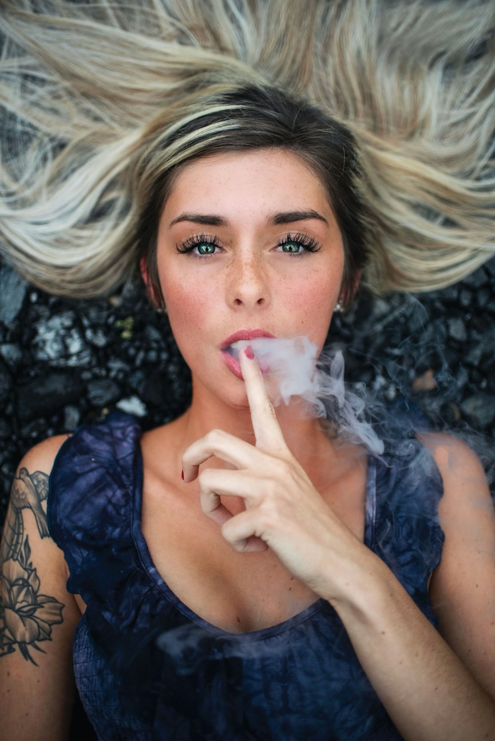 woman lying with smoke on mouth