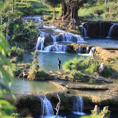 person standing on rock at river during daytime