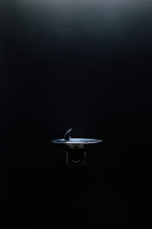 Close-up of a smart pet water fountain glowing softly with mint green accents, reflecting modern tech-minimalism design.