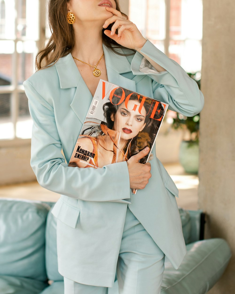 woman wearing blazer holding Vogue magazine