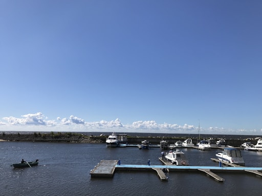 A serene marina scene with boats docked under a clear blue sky.