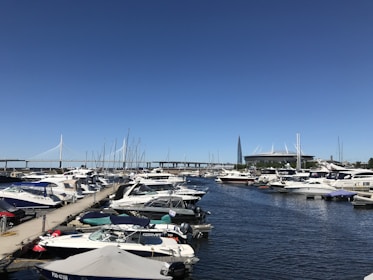 A vibrant marina with boats docked under a clear blue sky, ready for departure.