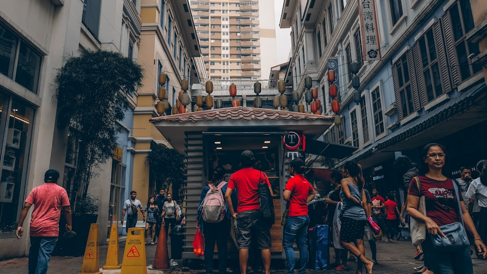 group of people standing near buildings ]