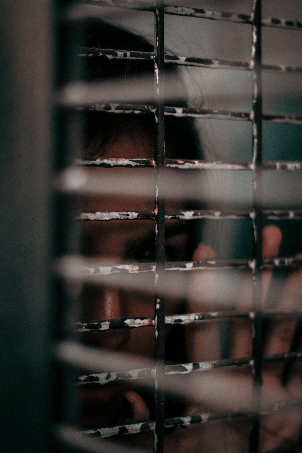 woman looking from a window grille