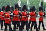 A group of people in traditional Scottish military uniforms standing in formation outdoors.