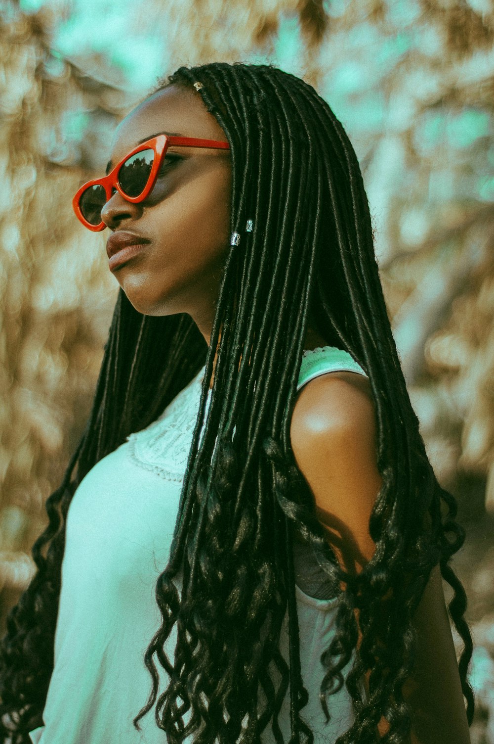 woman wearing teal shirt and red framed sunglasses