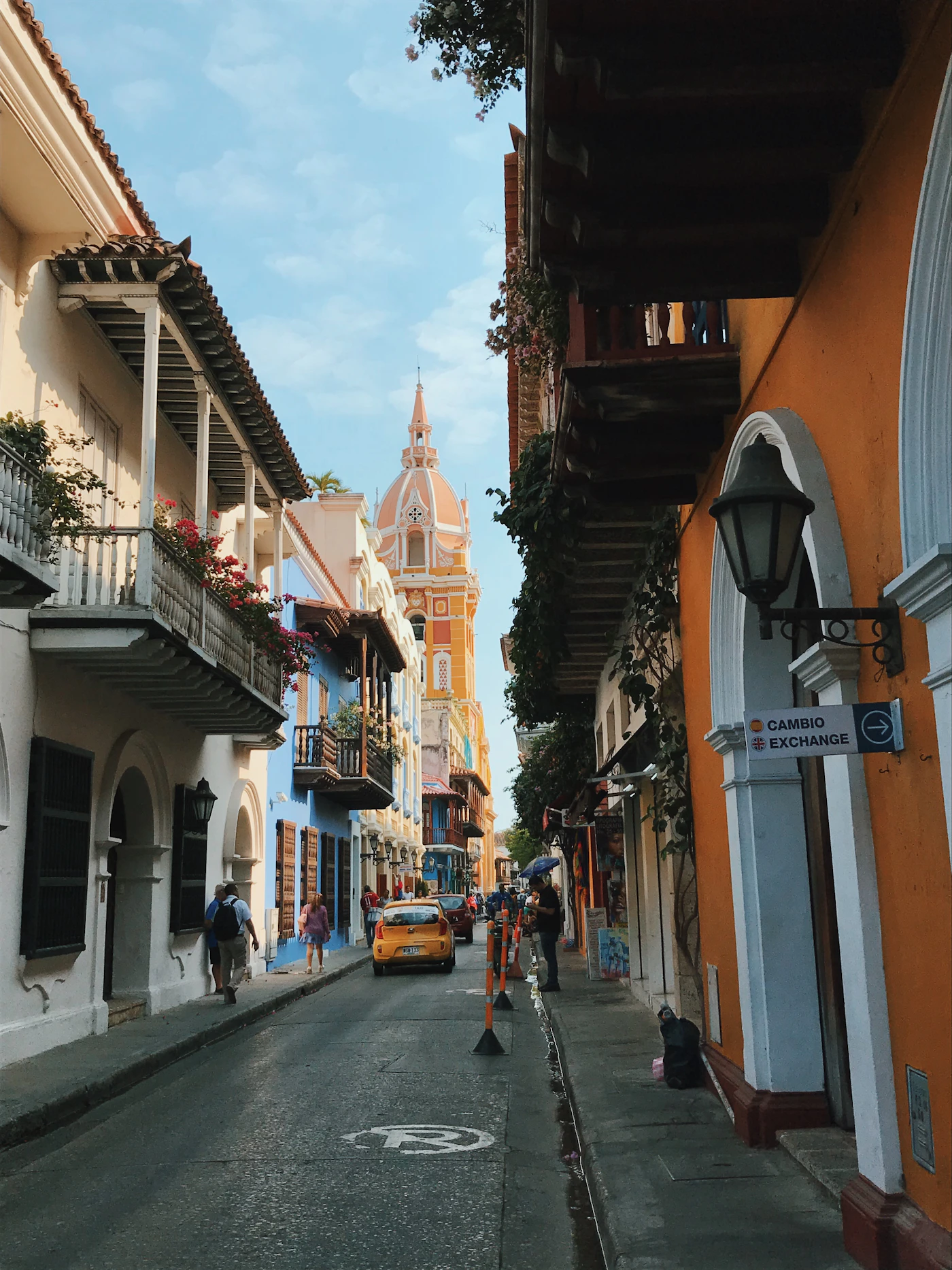Cartagena street in the morning with colourful horse-drawn carriage and colonial building facades in golden light