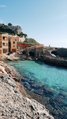 a body of water next to a rocky shore
