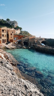 a body of water next to a rocky shore