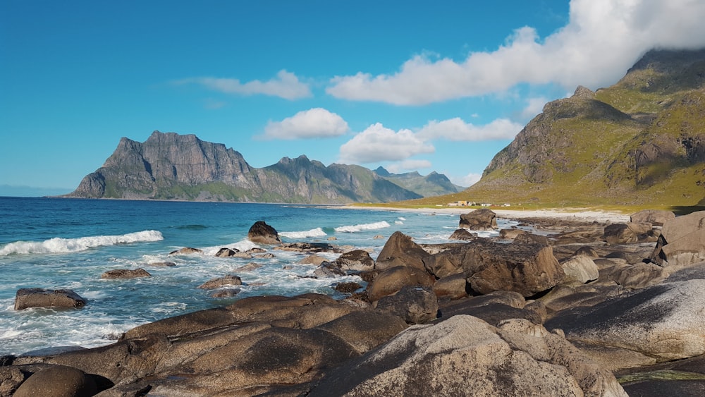 mountain range beside sea during daytime