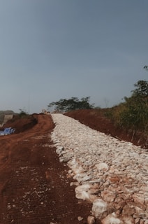 Sunset-lit dirt pathway freshly leveled and smoothed, ready for next stage of work.