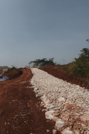 Sunset-lit dirt pathway freshly leveled and smoothed, ready for next stage of work.