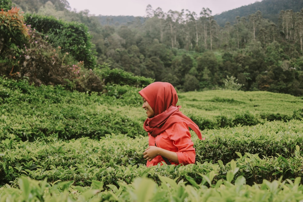 woman wearing orange hijab standing beside green plnat