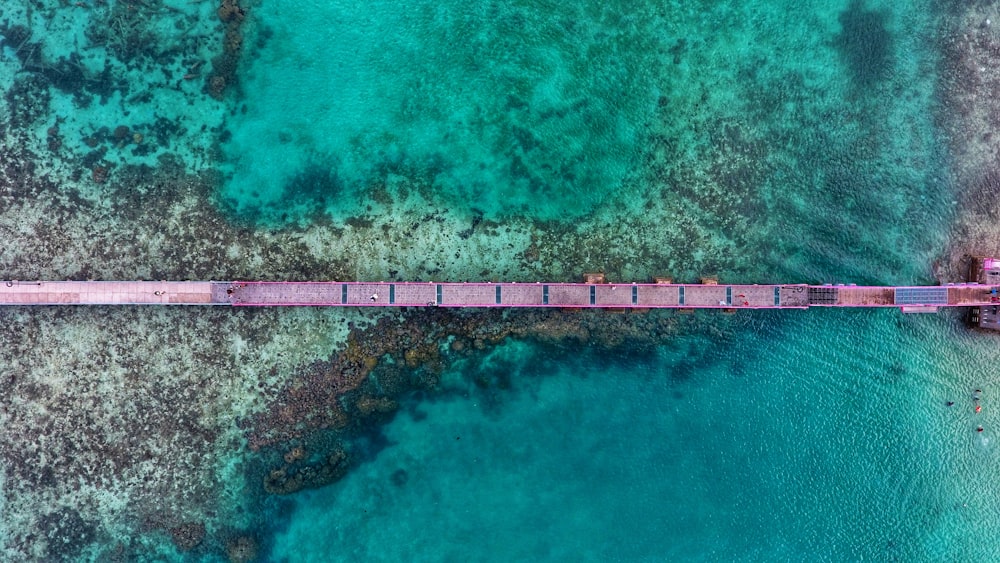 Fotografia aérea da ponte marrom sobre o mar