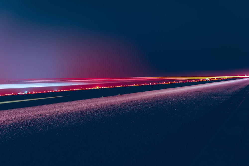 a long exposure photo of a highway at night