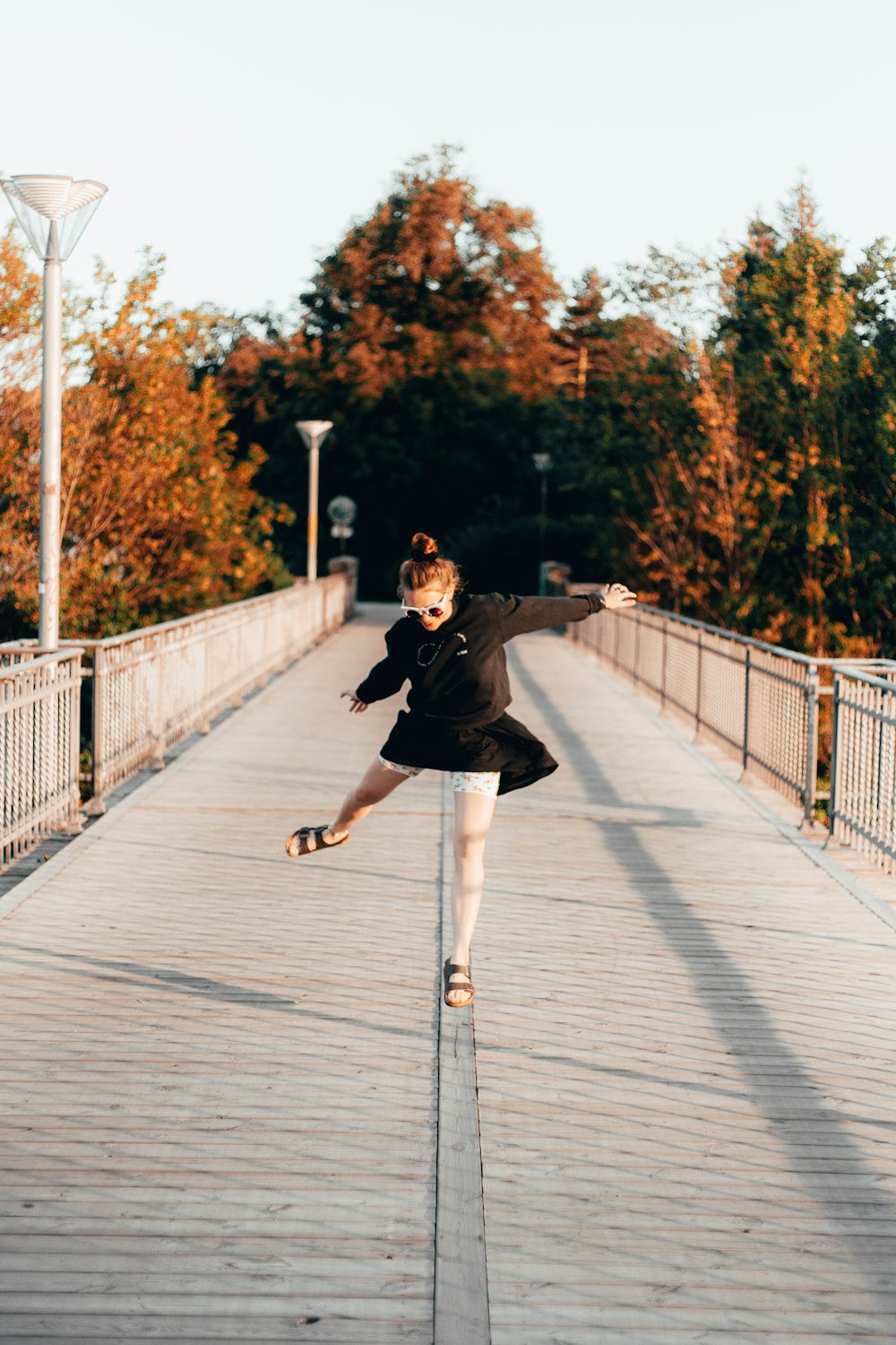 woman jumping on bridge