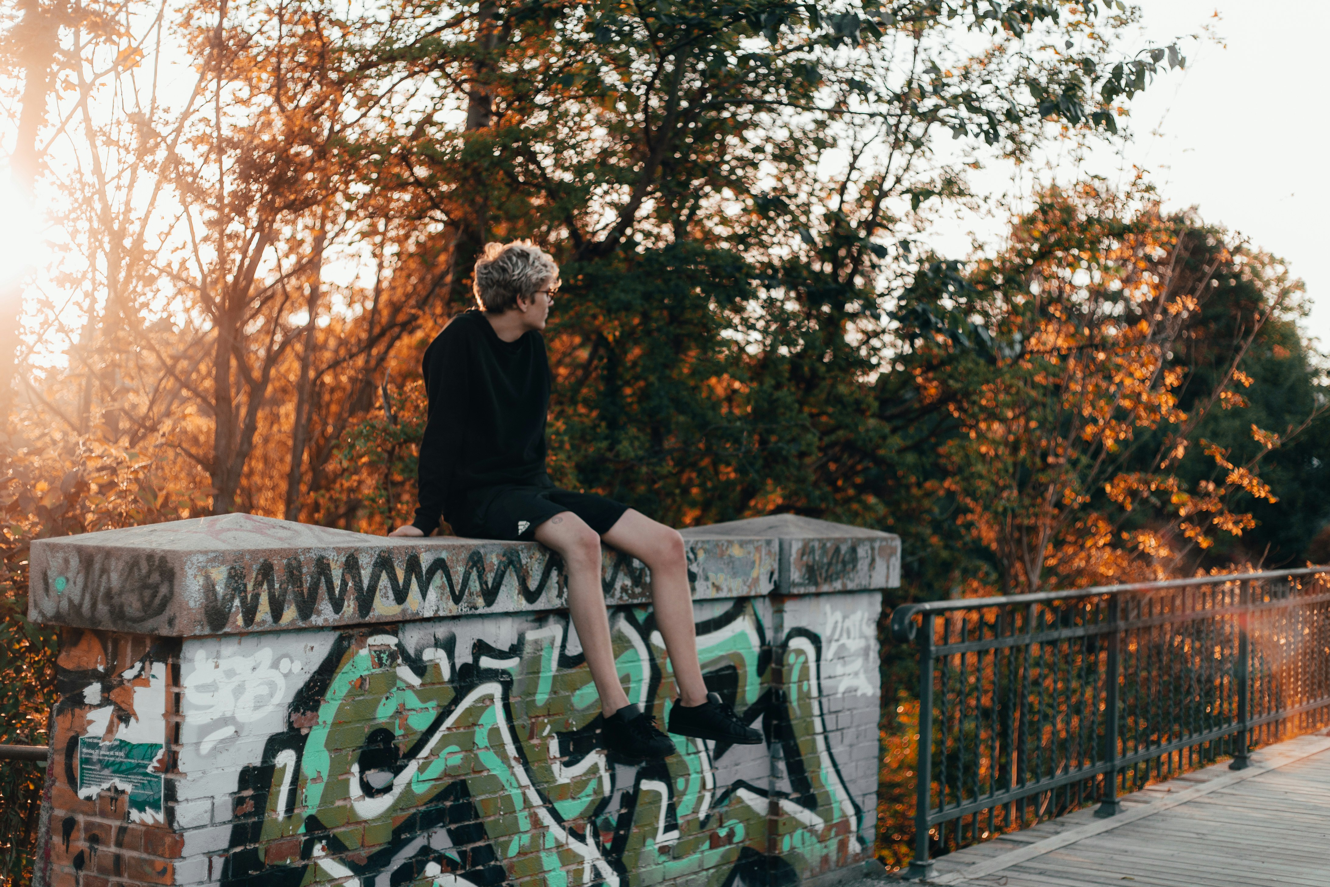 man sitting on the grey fence