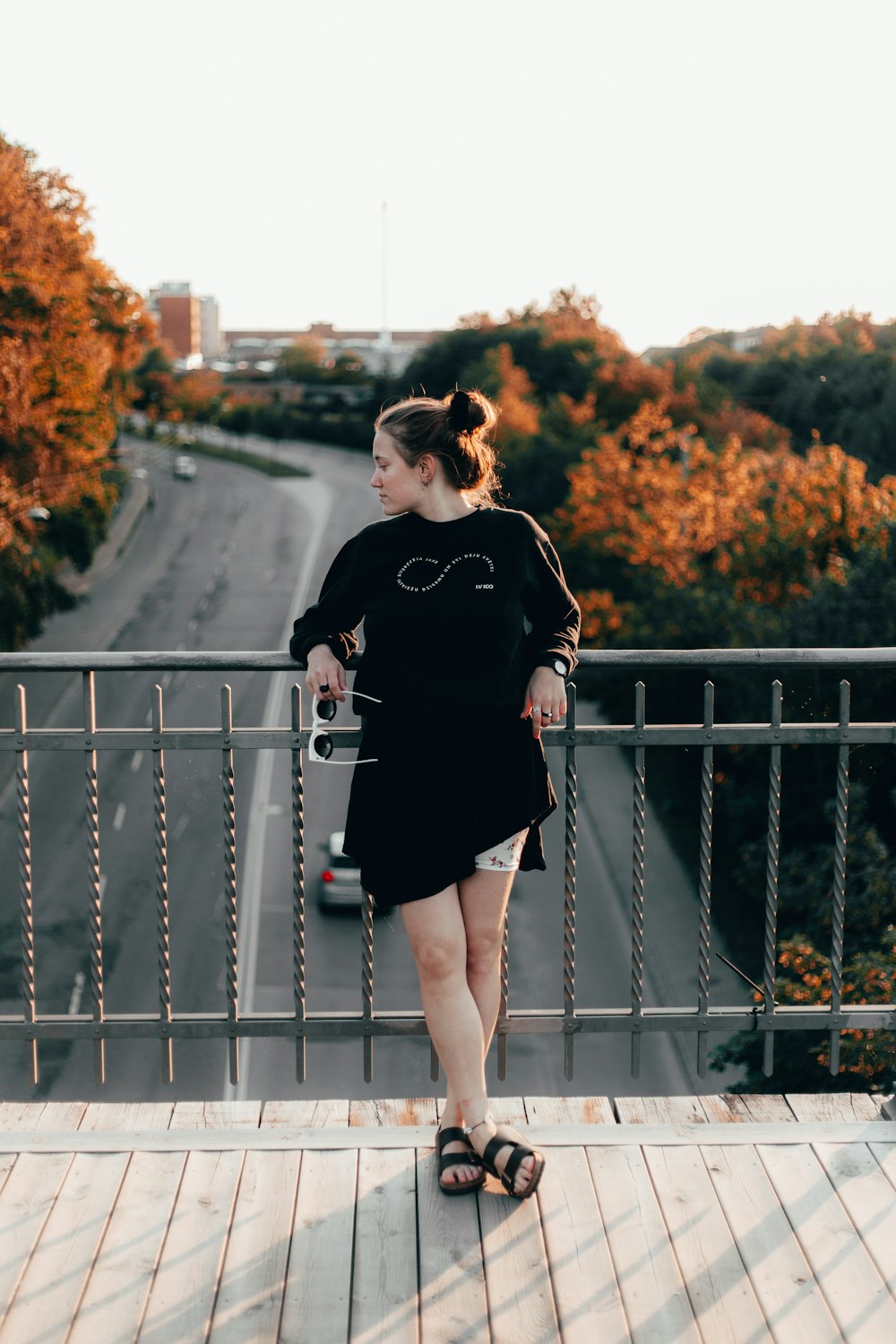 woman wearing black long-sleeved shirt leaning on gray stainless steel railings