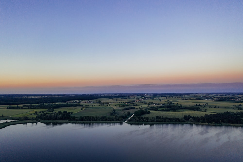 landscape photo of green fields and a lake