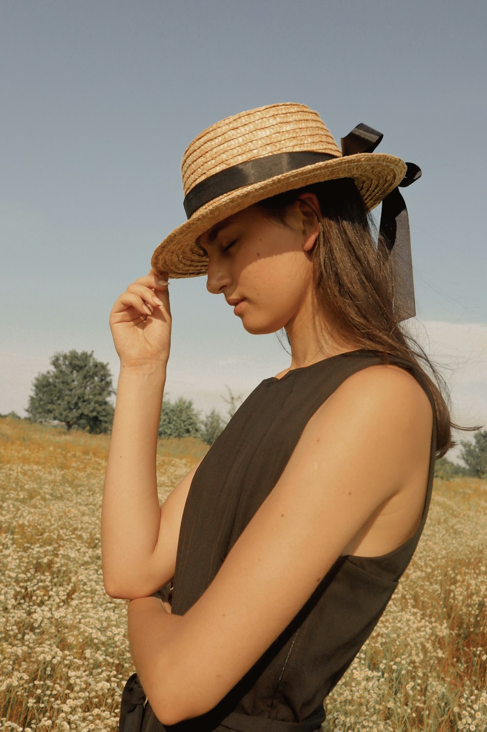 woman in beige and black hat and black sleeveless top