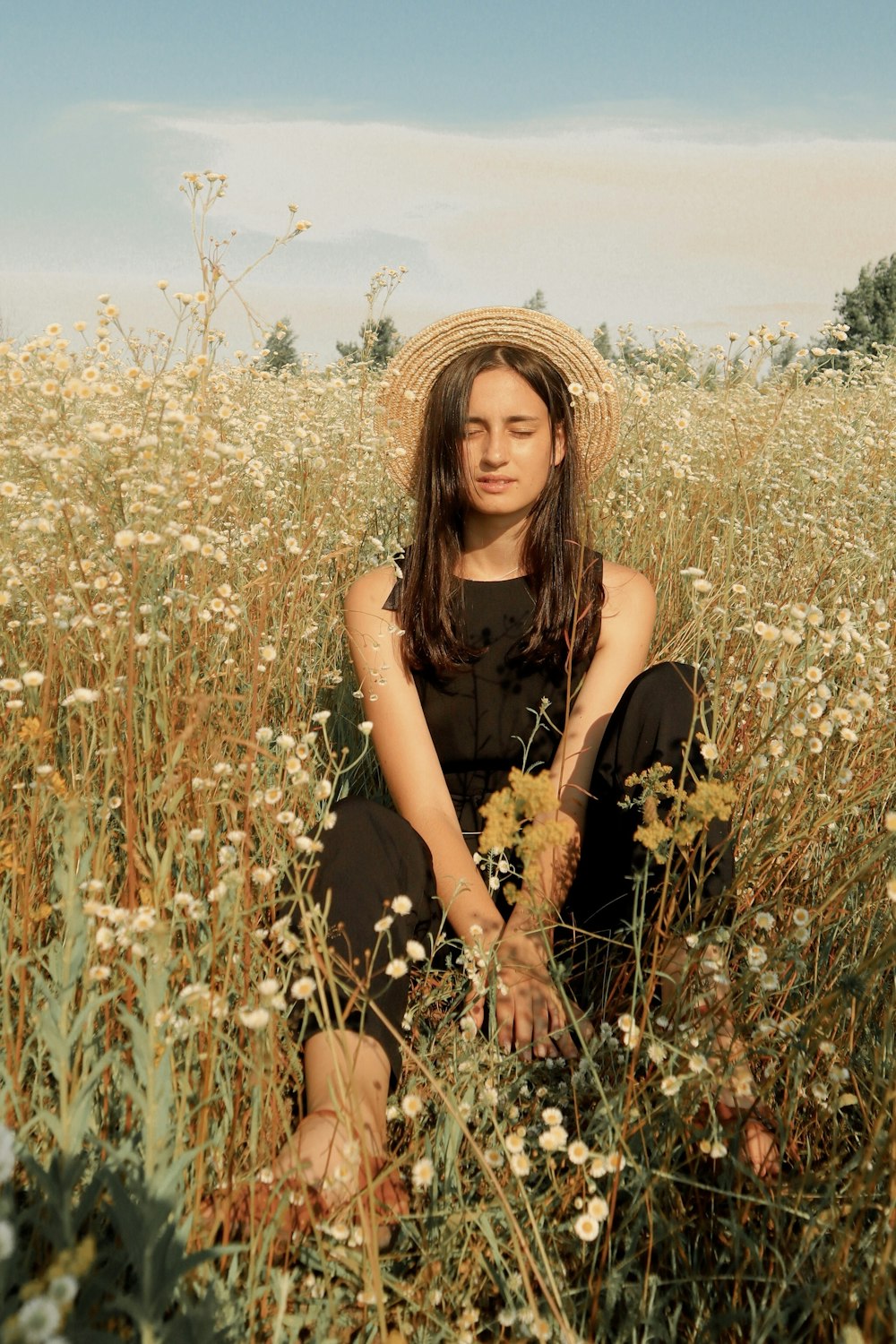 woman sitting surrounded by white flowers