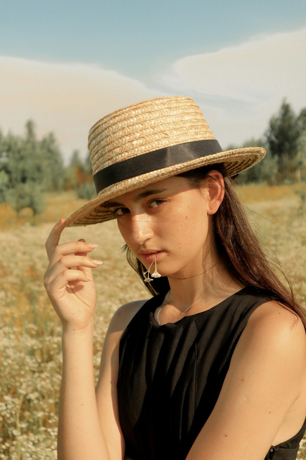 woman holding hat during daytime