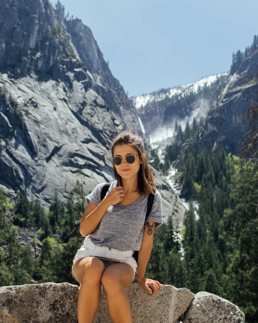 femme assise sur le rocher devant la montagne