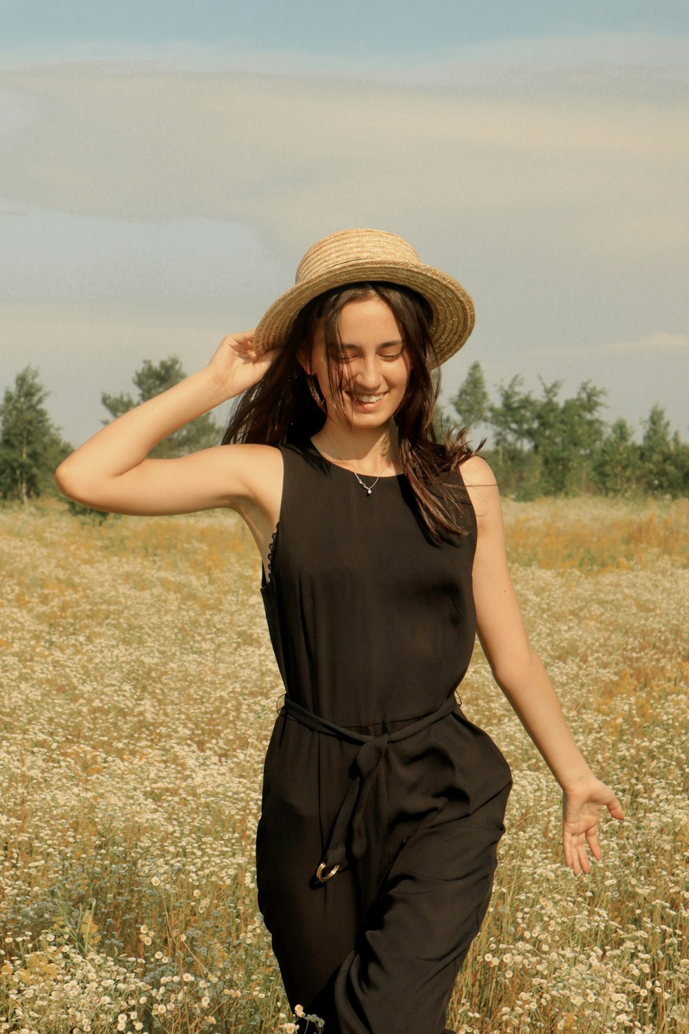 woman wearing black jumpsuit and sunhat