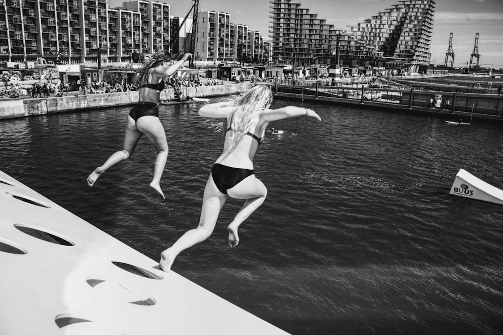 two women jumps on water