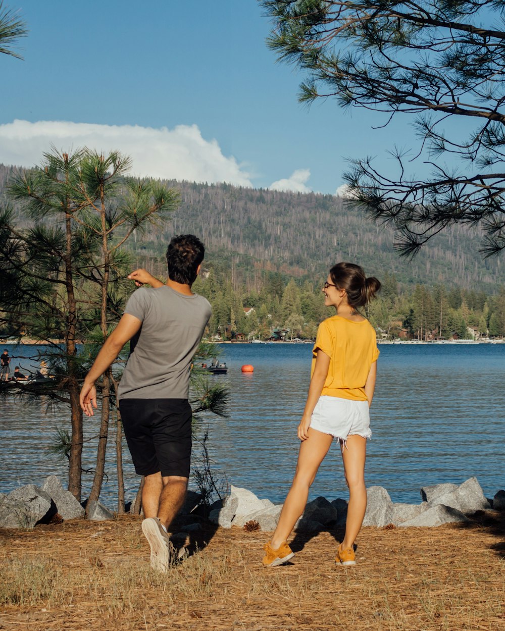 man and woman standing near body of water