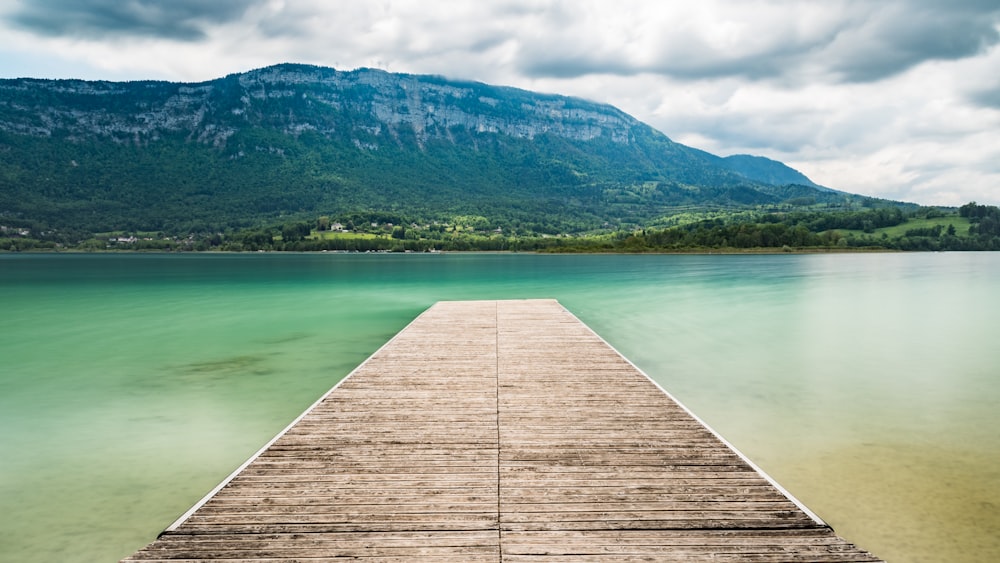 brown wooden pier on body of water