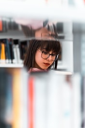 A focused individual reading a thick research paper in a cozy library corner.
