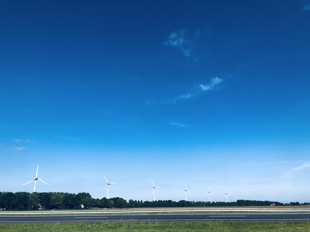 windmills on field under clear blue sky