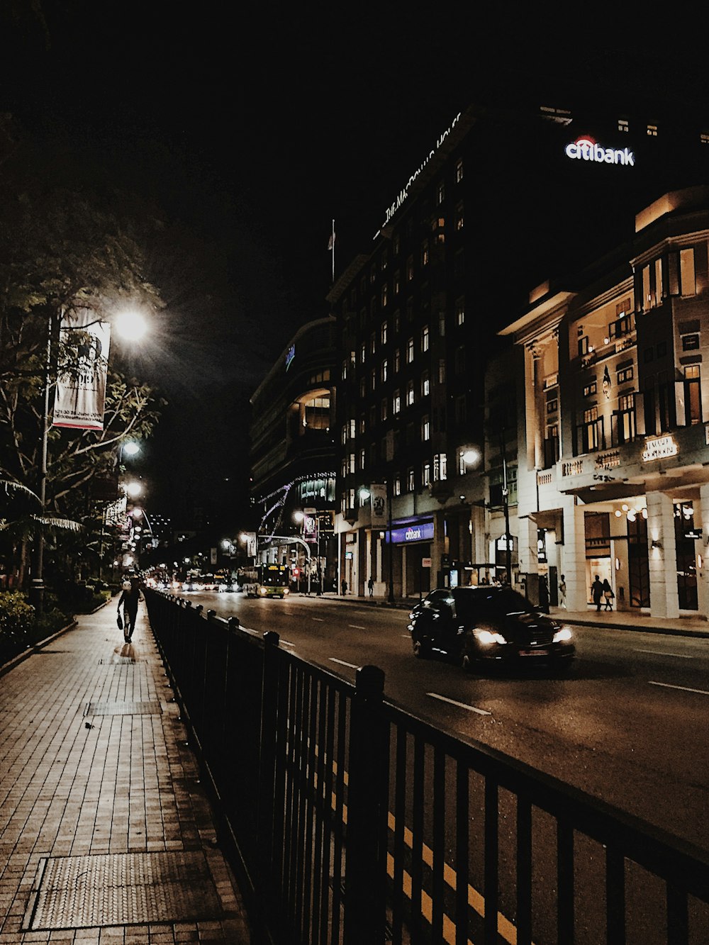 vehicle on road beside buildings during nighttime