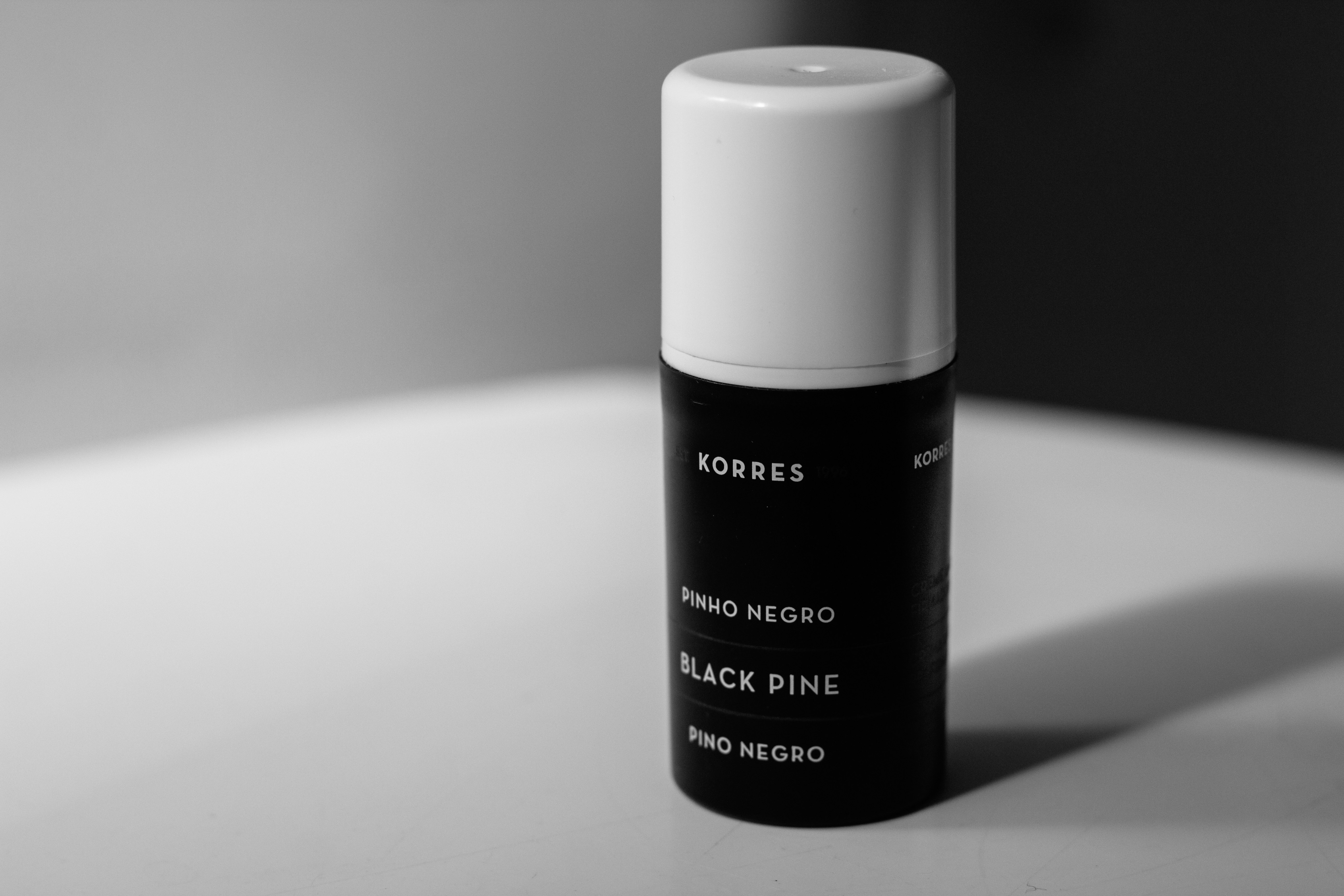 Korres black dine bottle on white surface
