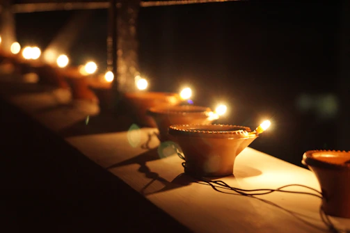 Rows of glowing temple lamps flickering softly in a quiet evening prayer.