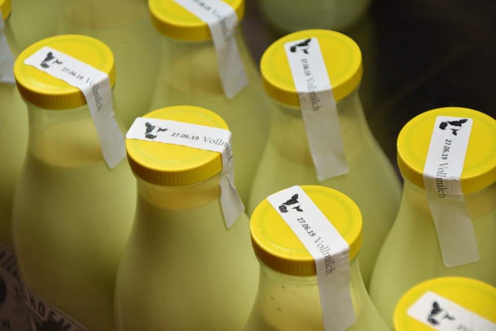 Milchflaschen mit gelben Verschlüssen, die mit weißen Klebebändern verschlossen sind