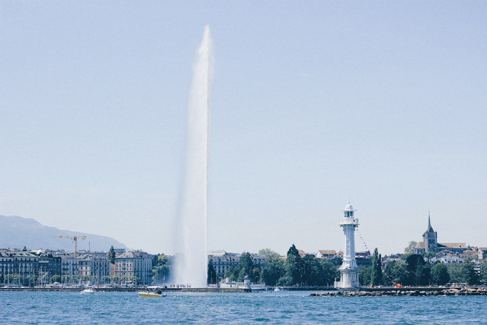 Faro blanco junto a la masa de agua durante el día