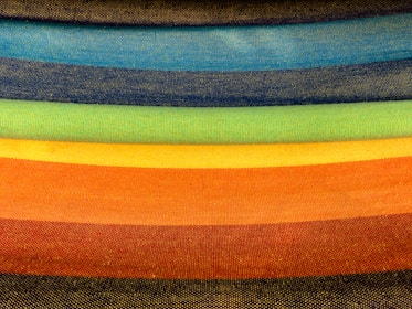 Stacks of colorful textile rolls neatly arranged in a bright studio.
