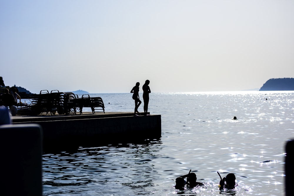 two person standing on dock