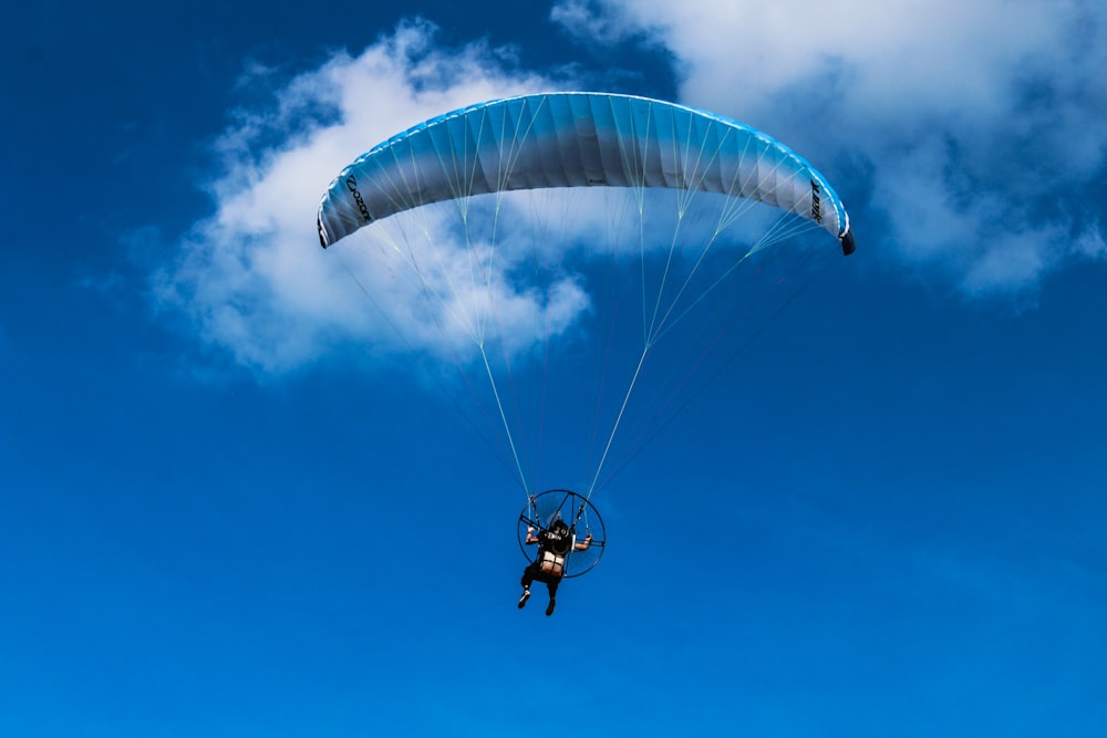 person riding parachute in mid air