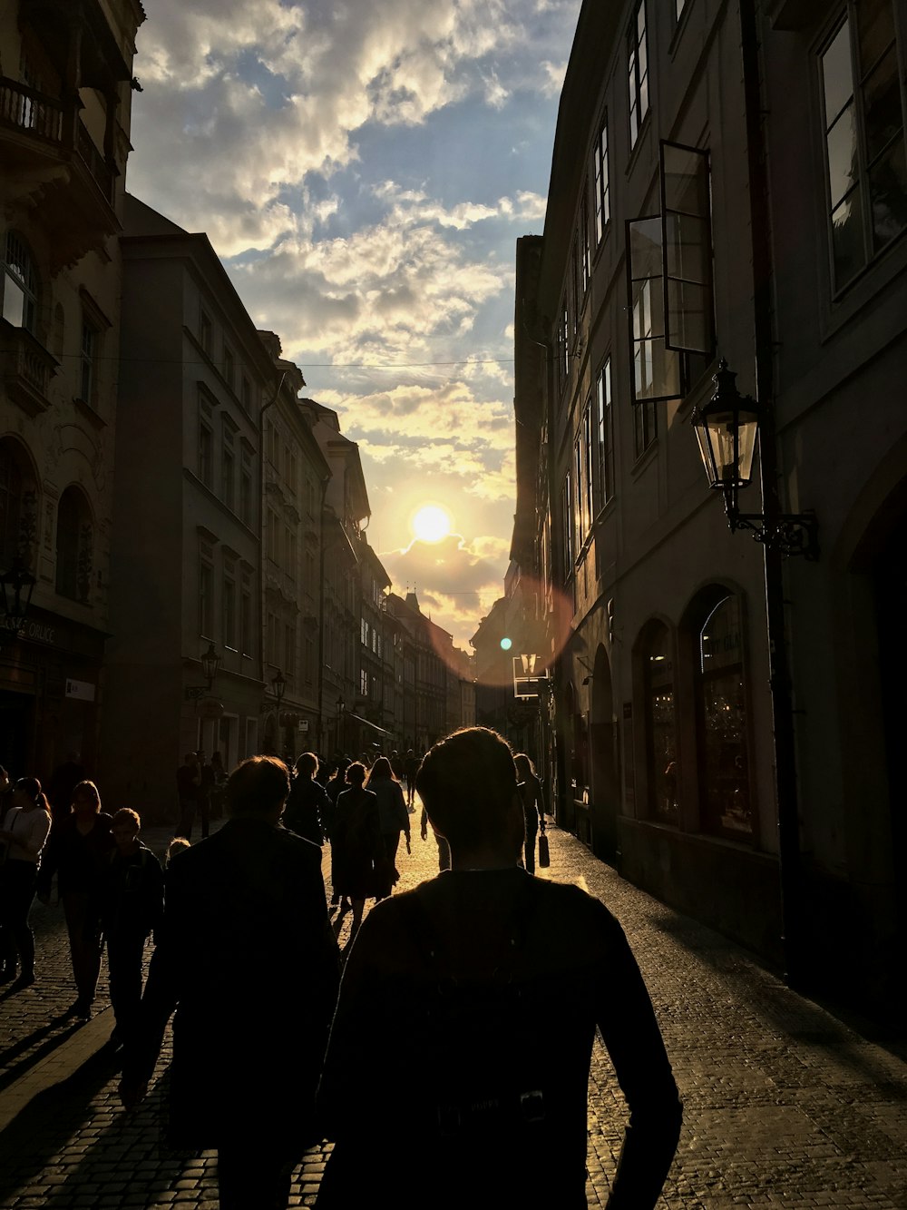 people walking near buildings during golden hour