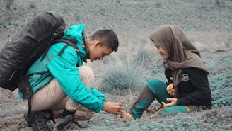 A volunteer helping a South Indian boy tie his school shoes, preparing him for a day of learning.
