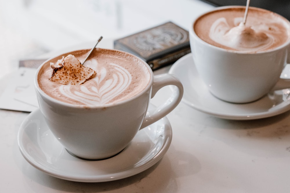 two white ceramic cups with saucers