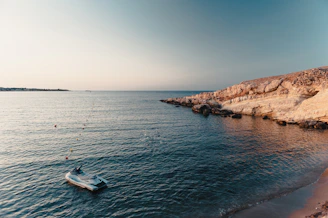 A serene early morning view of a sleek boat gently rocking on calm blue waters near La Spezia coastline.